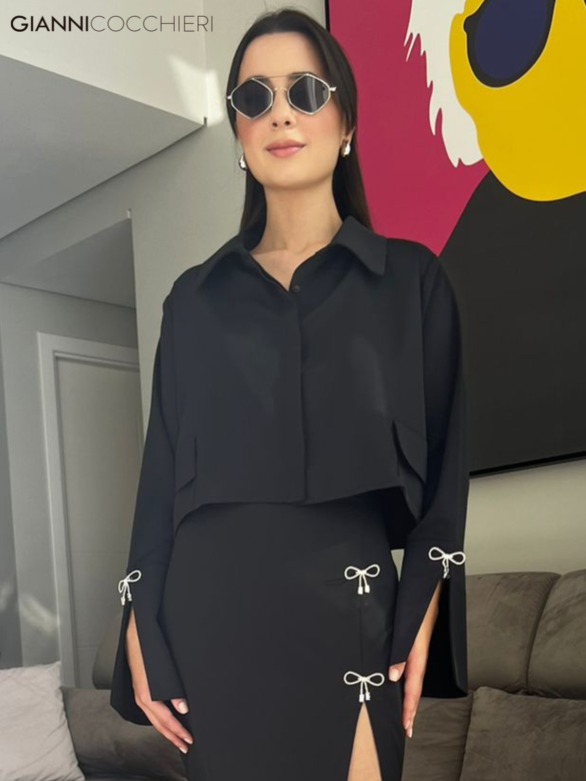 A camisa cropped preta é uma peça versátil e moderna que combina estilo e sofisticação. Os laços em strass adicionam um toque de glamour, elevando o visual.